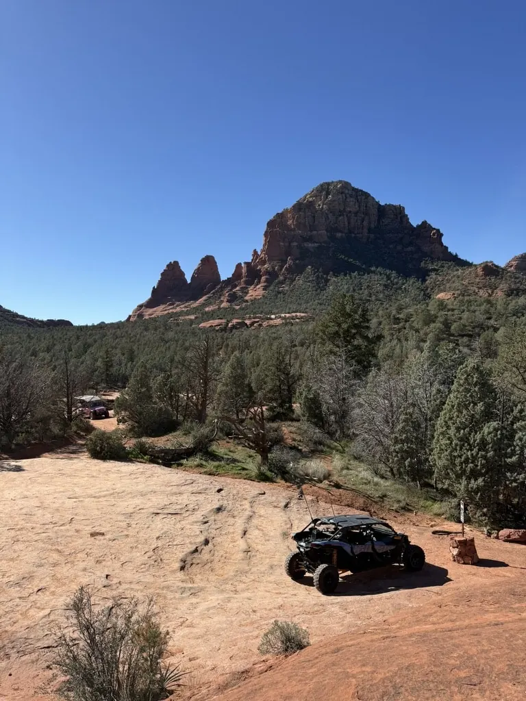 UTV rental group pausing on a desert overlook with mountain views