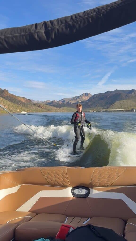 Wakesurfer Riding The Endless Wave Behind A Wave And Ridge Wakeboat